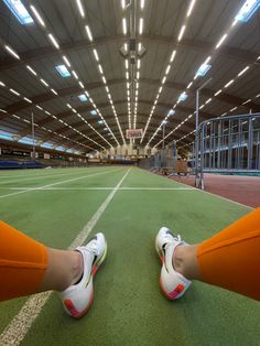 two people standing on a tennis court with their feet up