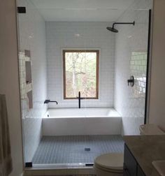 a bathroom with a tub, toilet and sink in it's center wall is shown