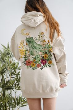 This is a Unisex-Style Watercolor Cottagecore Frog Hoodie. It is a super cool pullover hoodie that is blank on the front with a trendy back print featuring a beautiful collage of a watercolor frog surrounded by botanical and floral illustrations. The soft, warm material is made from a blend of cotton and polyester. It has a front kangaroo-style pocket and no side seams. It is a tried and true hoodie, sure to become your favorite. SIZE UP 2-3 SIZES FOR THE TRENDY, OVERSIZED LOOK! :) If you need a Moth Hoodie, Cottage Core Clothes, Core Clothes, Clothes Cottagecore, Mushroom Hoodie, Moth Sweater, Cottagecore Sweater, Tried And True, Cottage Core