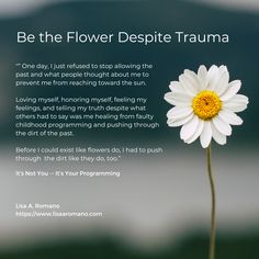 a white flower sitting on top of a wooden table next to a quote about flowers