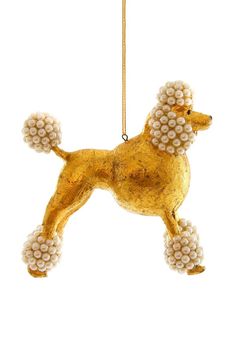 a golden poodle ornament hanging from a gold chain on a white background