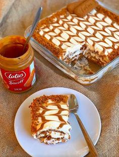 a piece of cake sitting on top of a white plate next to a jar of syrup