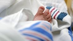 a baby's foot is tucked under a blanket