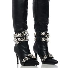 Edgy Elegance Starts With The Azalea Wang " Spotlight Takeover " Diamond Embellished Boot. This Glamorous Faux Leather Boot Features A Pointed Toe Silhouette, A Slim Stiletto Heel, A Knee-Height Shaft, And A Tonal Inner Ankle Zipper Closure. Complete With Silver Metallic Hardware, Chunky Rhinestone Gemstones, And Rhinestone Belted Accents Across The Calves And Toes. Style With A Midi Skirt And A Corset Top For A Romantic Look. - Faux Leather Upper - Pointed Toe - Stiletto Heel - 16.25 ” Shaft He Pointed Toe Rhinestone Cocktail Boots, Cocktail Boots With Rhinestones And Pointed Toe, Cocktail Rhinestone Boots With Pointed Toe, Glamorous Embellished Boots For Formal Occasions, High Heel Rhinestone Boots For Cocktail, Evening High Heel Boots With Rhinestones, Cocktail High Heel Boots With Rhinestones, Chic Formal Bling Boots, Glamorous Rhinestone Cocktail Boots