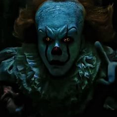 a creepy clown with red hair and blue eyes