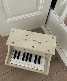 a toy piano sitting on the floor in front of a door with words written on it