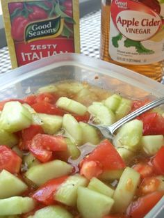 a container filled with sliced up vegetables next to a bottle of apple cider vinegar