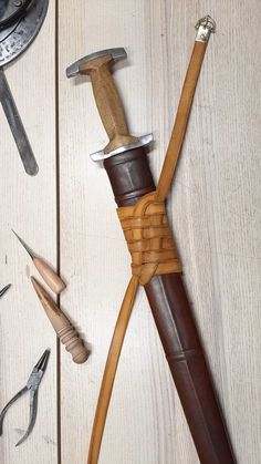 a hammer, pliers and other tools are laid out on a white wooden surface