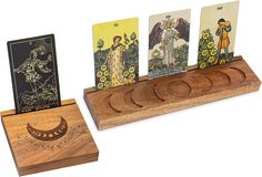 four cards are in a wooden holder with three different designs on them, and one is holding the same tarot card