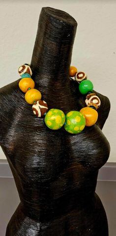 Even though this is a new listing, I am placing it in the FINAL SALE collection since I am not entirely pleased with the way the paint behaved on this piece. Large and oversized hand sculpted beads are painted in a variety of colors: orange with a color shift glaze, green and yellow polka dot with a color shift glaze, lime green, African batik patterned beads, agate, coconut, resin and African glass. Most beads are separated with tiny turquoise spacers. The sculpted beads are sealed with a satin Artistic Green Necklace For Festivals, Unique Wooden Beaded Necklaces, Unique Green Wooden Beads, Green Wooden Beaded Necklaces, Unique Green Wooden Beaded Necklaces, Yellow Wooden Beads, Unique Yellow Wooden Beads, Unique Green Necklaces With Wooden Beads, Green Wooden Beads Necklaces For Festivals