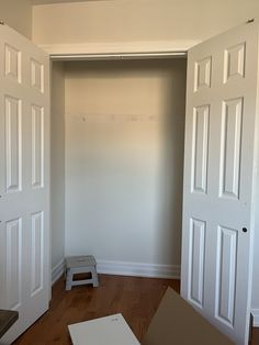 an empty room with two open doors and a step stool