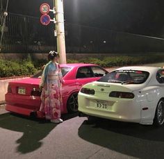 two cars are parked next to each other on the side of the road at night