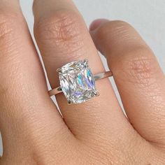 a woman's hand with a ring on it and a diamond in the middle