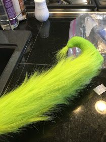 a green furry animal tail sitting on top of a counter