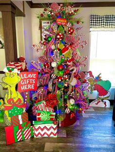 a brightly colored christmas tree is decorated with candy canes and candies for the holiday season