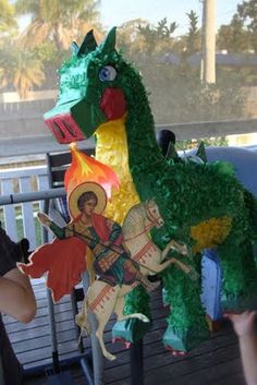 a woman standing next to a statue of a green dragon on top of a wooden fence