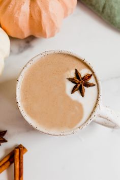 an overhead view of a cup of hot chocolate with cinnamon and star anise on the side