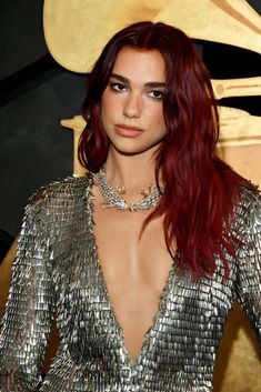 a woman with red hair wearing a silver dress