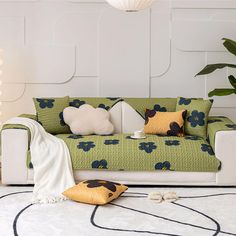 a green and white couch sitting in a living room next to a potted plant