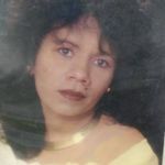 an old photo of a woman with big hair and blue eyes, wearing a yellow dress