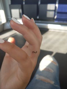 a person's hand with a tiny ring on their thumb and the word love written in black ink