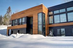 a large house with lots of windows on top of it in the snow covered ground