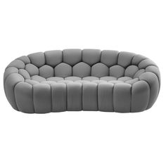 a gray couch with rounded cushions on it's back and arms, sitting in front of a white background