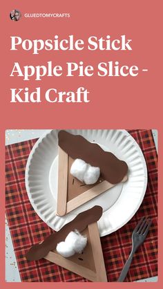 popsicle stick apple slice kid craft on a paper plate with fork and spoon next to it