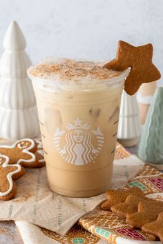 there is a cup of iced coffee and some cookies on the table next to it