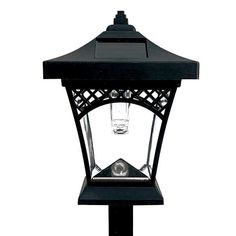 a black lantern with a clear glass on it's top and an iron base