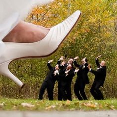 a group of people in black suits and white shoes with their feet up on the ground