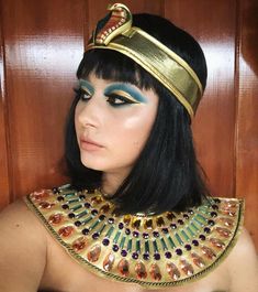 an egyptian woman with black hair and gold jewelry on her head, wearing a costume