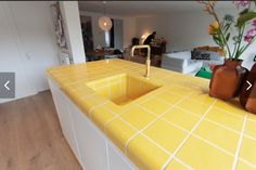 a kitchen with yellow counter tops and vases