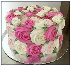 a large cake with pink and white flowers on it