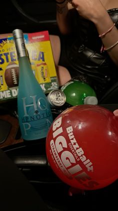 a red ball sitting on top of a table next to a woman's hand