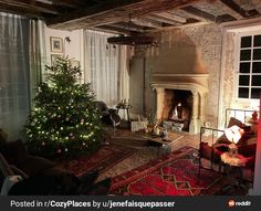 a living room filled with furniture and a christmas tree in front of a fire place