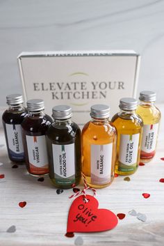 six bottles of liquid are on a table with confetti around them and a sign that says, elevate your kitchen