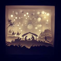 the nativity scene is made out of paper and lit up by lights in the dark