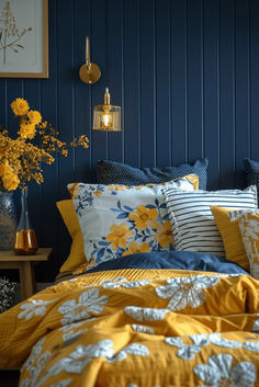 a bedroom with blue walls and yellow flowers in vases on the nightstand next to the bed