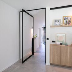 an open door leading to a hallway with a potted plant on the sideboard