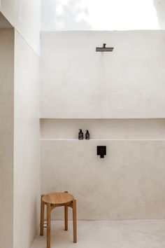 a small wooden table sitting in the middle of a room with a skylight above it