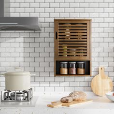 a kitchen with white tiles and wooden shelves on the wall, cooking utensils