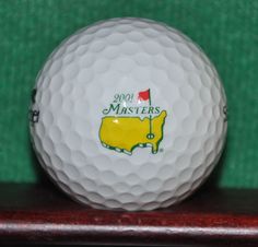 a golf ball with the logo of your masters on it sitting on a wooden stand