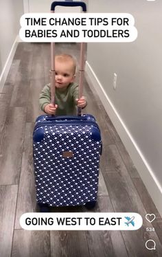 a baby is pushing a blue suitcase down the hallway with text reading time change tips for babies and toddlers going west to east