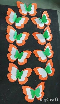 several orange and white butterflies with green leaves on them, arranged in the shape of a circle