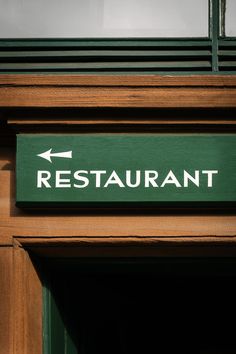 a restaurant sign on the side of a building with an arrow pointing to the right