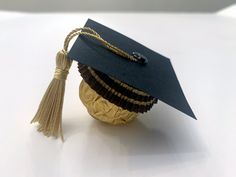 a graduation cap is placed on top of a gold ball that has been decorated with tassels