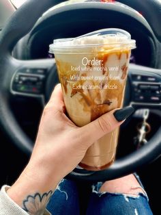 a woman holding up a cup of iced coffee in her hand with the words order printed on it