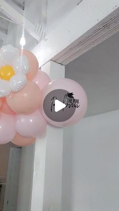 some balloons are hanging from the ceiling with an egg on them and one balloon is in the shape of a flower