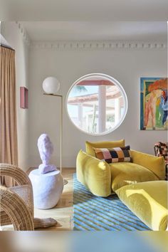 a living room filled with furniture and a round window